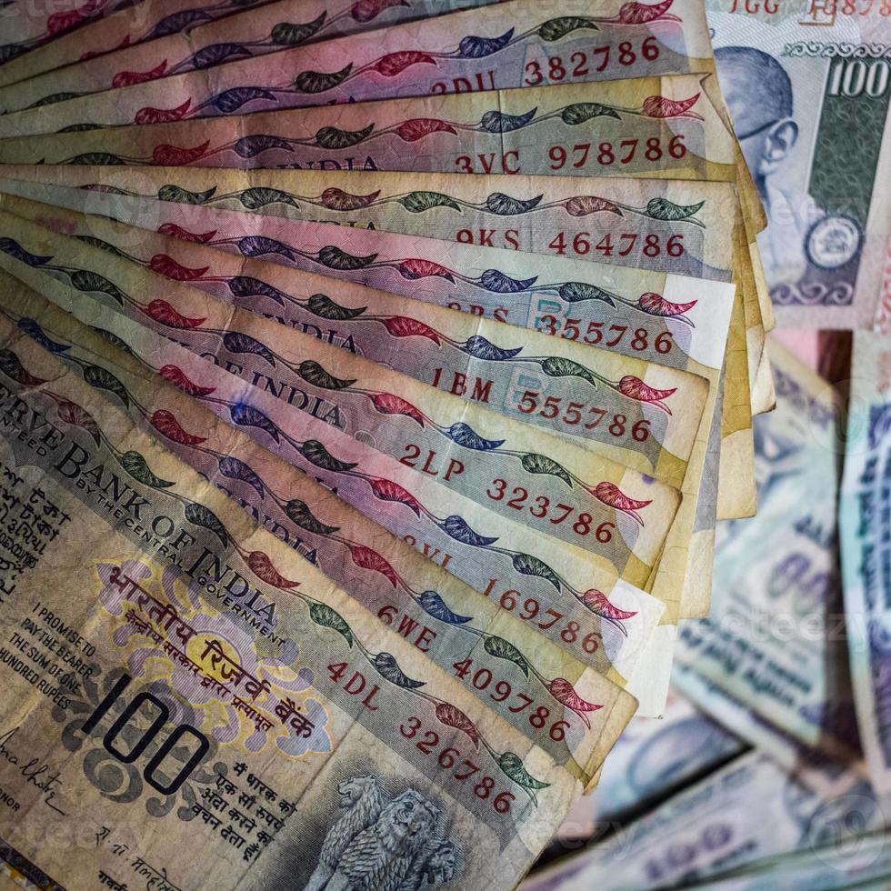 Old One Hundred Rupee notes combined on the table, India money on the rotating table. Old Indian Currency notes on a rotating table, Indian Currency on the table photo