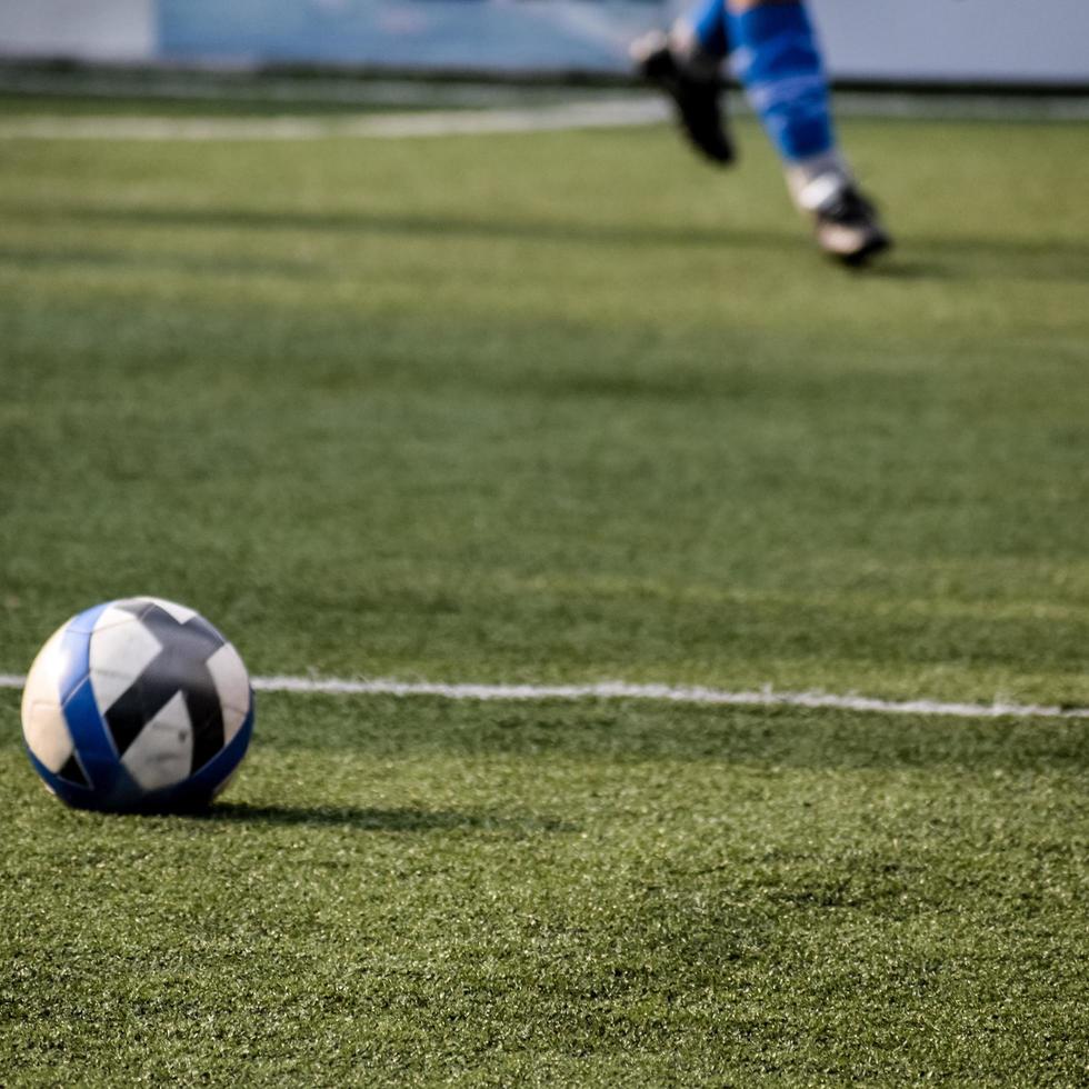 nueva delhi, india - 01 de julio de 2018 futbolistas del equipo de fútbol local durante el partido en el campeonato regional derby en un mal campo de fútbol. momento caliente del partido de fútbol en el campo verde de hierba del estadio foto