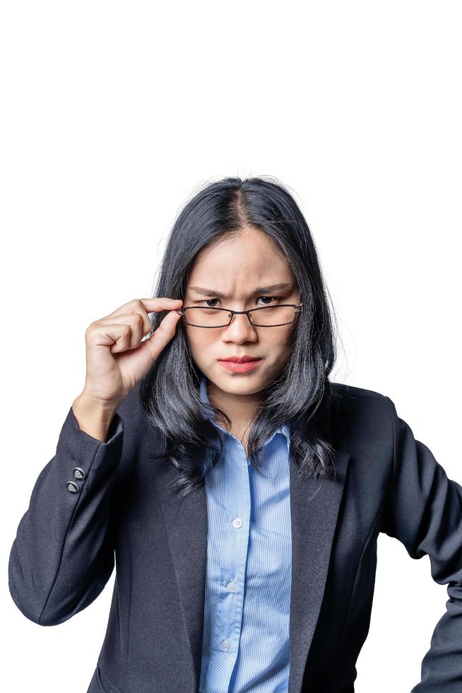 retrato de una joven empresaria sospechosa y arrogante mirando por encima de sus gafas. especialista en negocios asiática segura de sí misma con una mirada despectiva mirando a la cámara. concepto de emprendedor foto