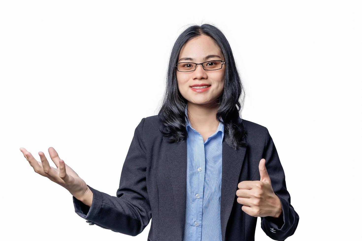 Close-up portrait of confident businesswoman showing thumb up with hand to presenting or pointing isolated on white background. Beautiful young female showed fingers hand symbol ok photo