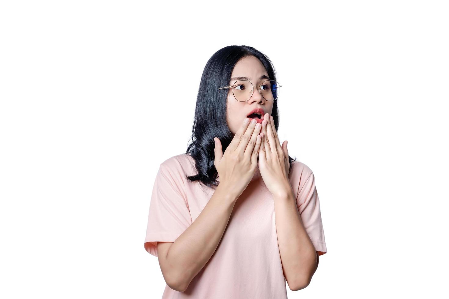 Surprised beautiful woman holding her cheeks by hand in amazement and open-mouthed. Happy young female model looks at camera as notices something unexpected hears good news. photo