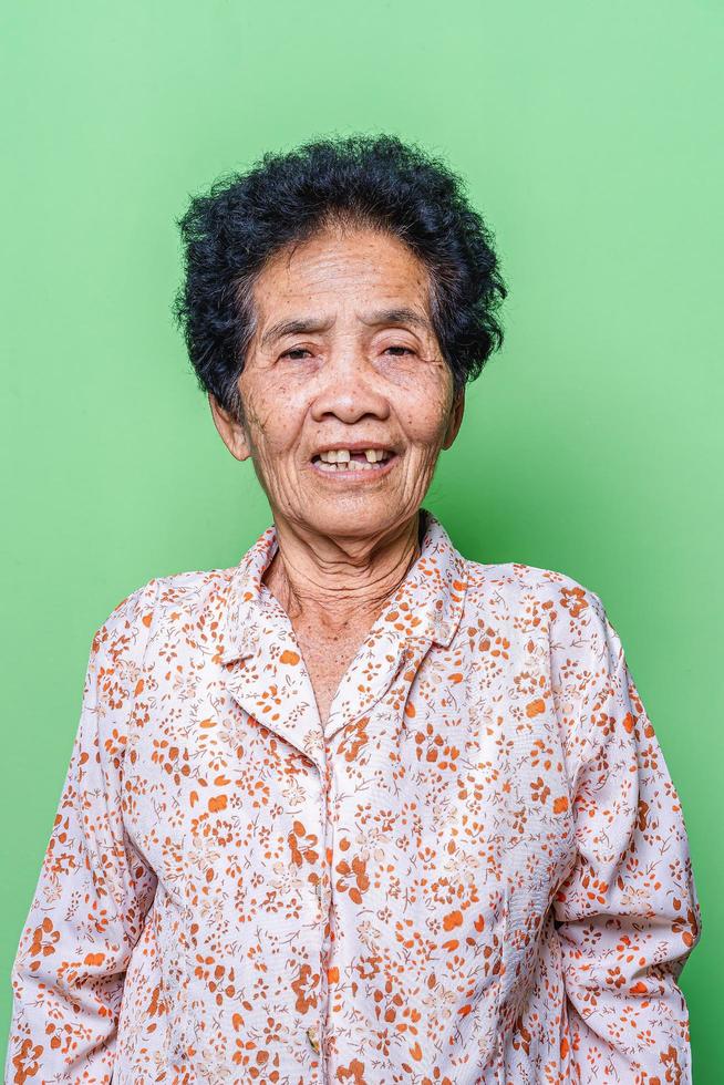 Close-up of old Asian woman face with wrinkles elderly senior.smiling happiness with a few broken teeth  looking at the camera. photo