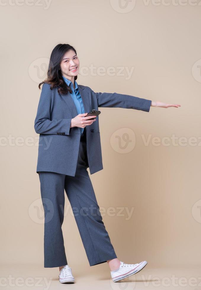Full length image of young Asian business woman on background photo