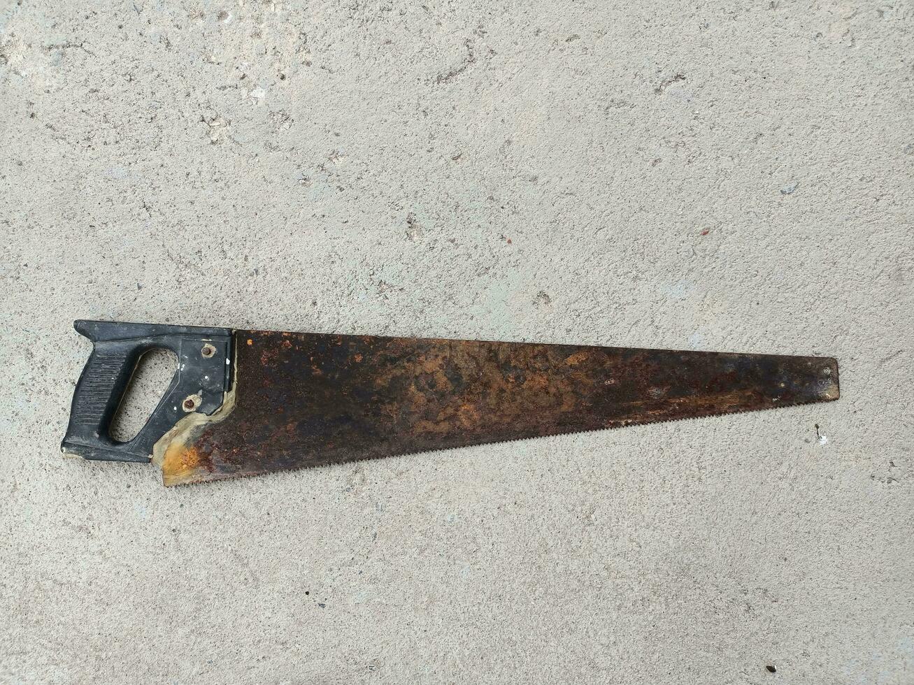 Brown rusted saw blade on the floor. photo