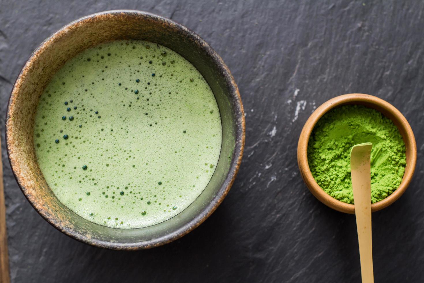 green matcha tea prepearing on stone black table photo