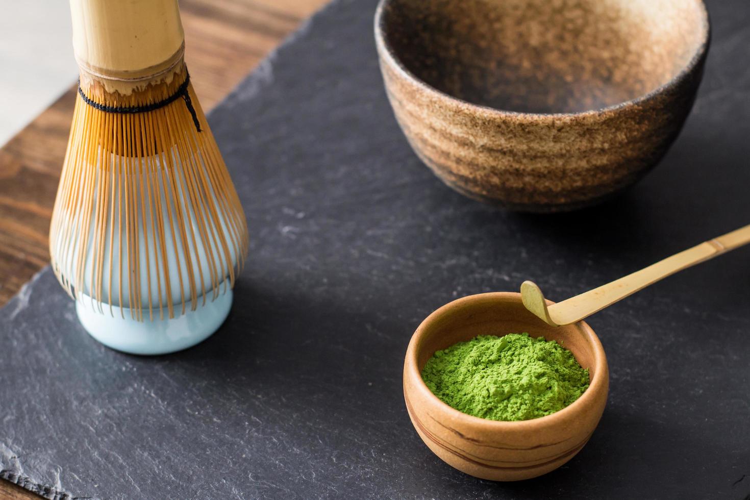 green matcha tea prepearing on stone black table photo