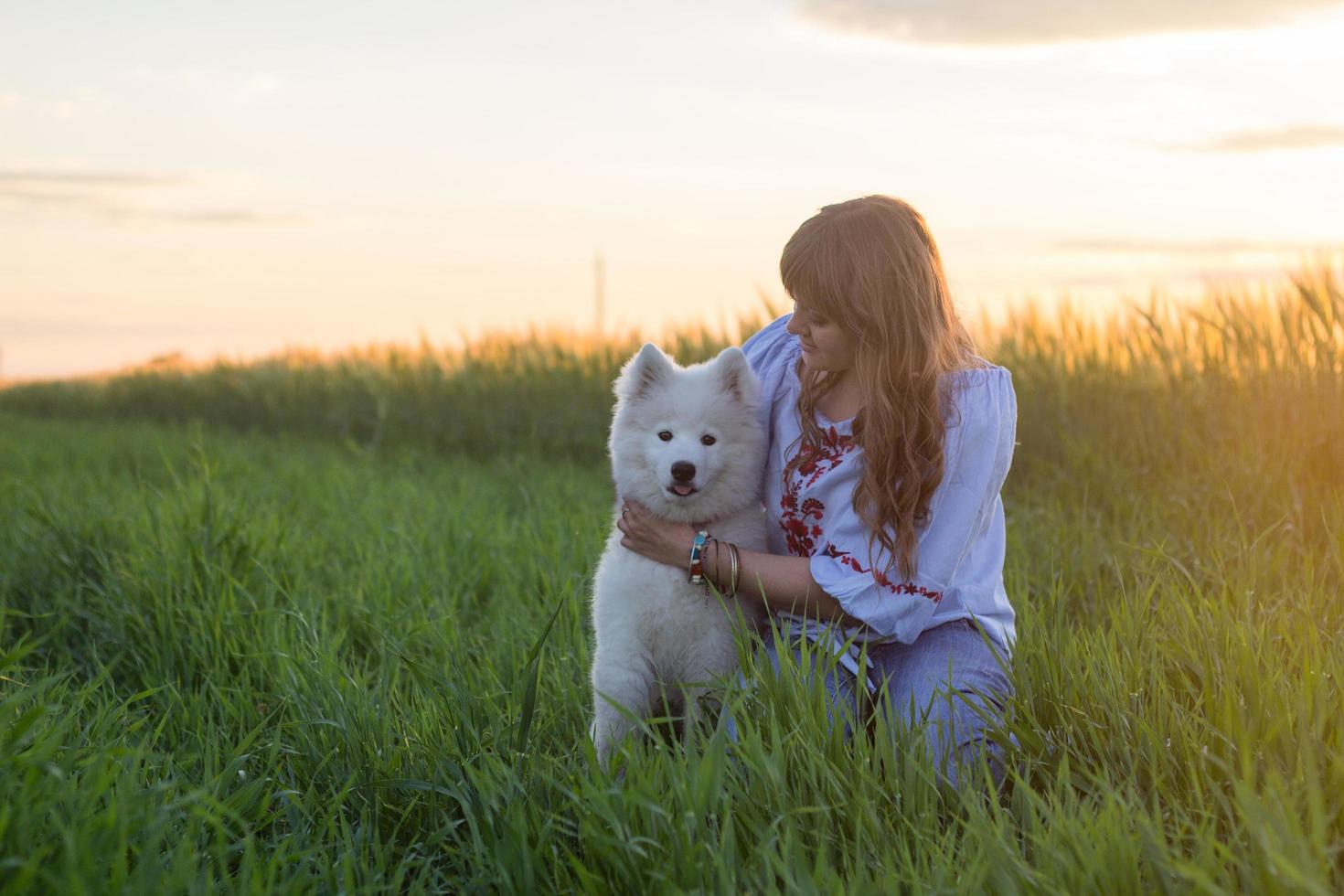 portrait of woman and white puppy of husky dog in the fields photo