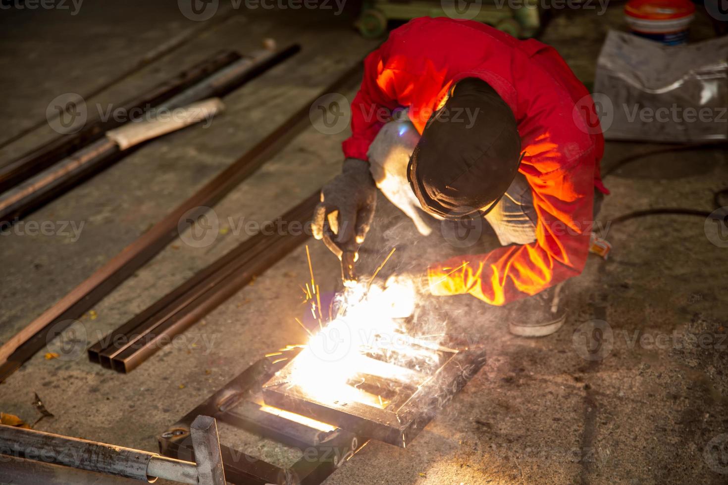 soldador utilizó piedra de moler sobre acero en fábrica con chispas, proceso de soldadura en el taller industrial, manos con instrumento en marco. foto