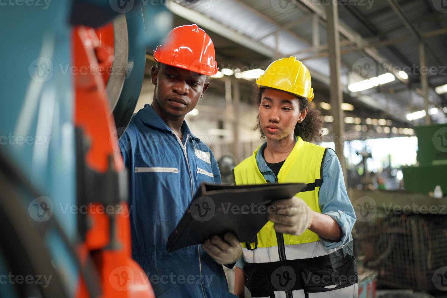 Maintenance Engineers is working in front of the automated CNC machinery repair on a maintenance checklist at the production line. photo