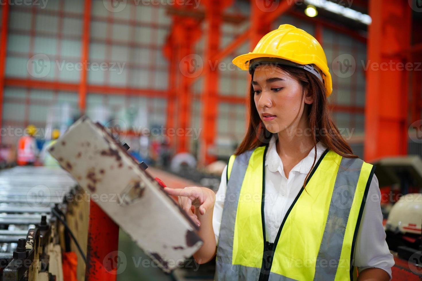 la capataz de la trabajadora o el trabajo del trabajador en el sitio de la fábrica revisan la máquina o los productos en el sitio. ingeniero o técnico revisando material o máquina en planta. industrial y fábrica. foto