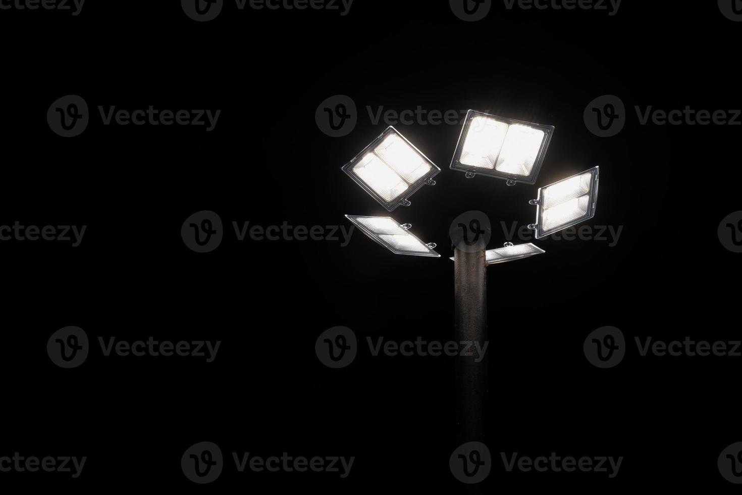 Silhouette lighting pole, street light or lamppost illuminating by solar cell panel at night sky background. Selective focus and copy space. Renewable energy concept. photo