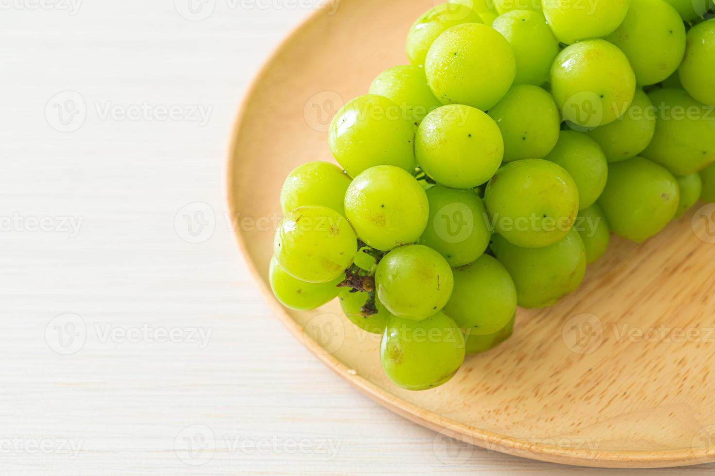 fresh green grape on wood plate photo