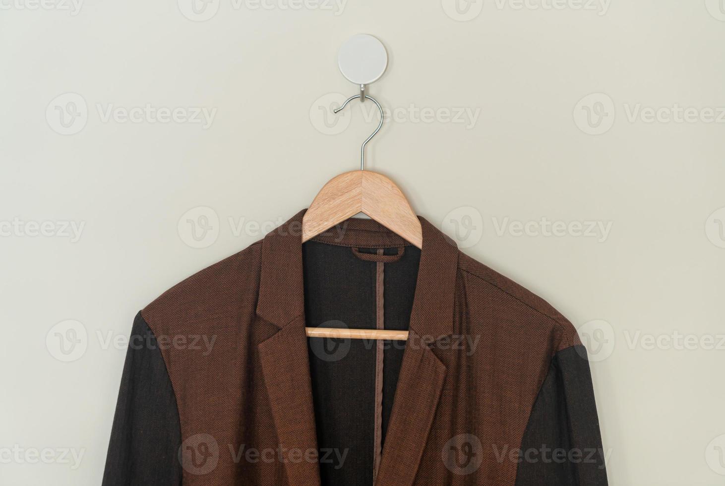 beige suit hanging with wood hanger photo