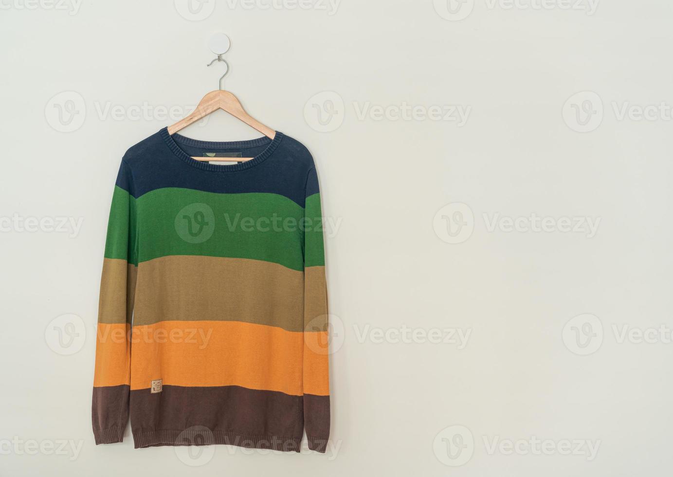 colorful sweater hanging with wood hanger photo