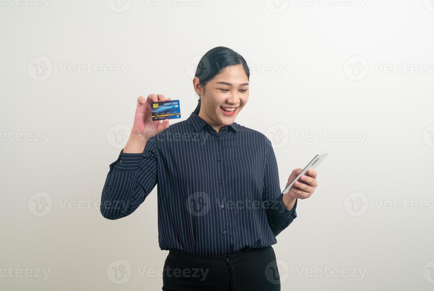 mujer asiática que usa un teléfono inteligente con una tarjeta de crédito en la mano foto