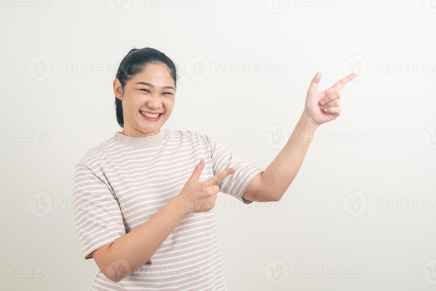mujer asiática con la mano apuntando a la pared foto