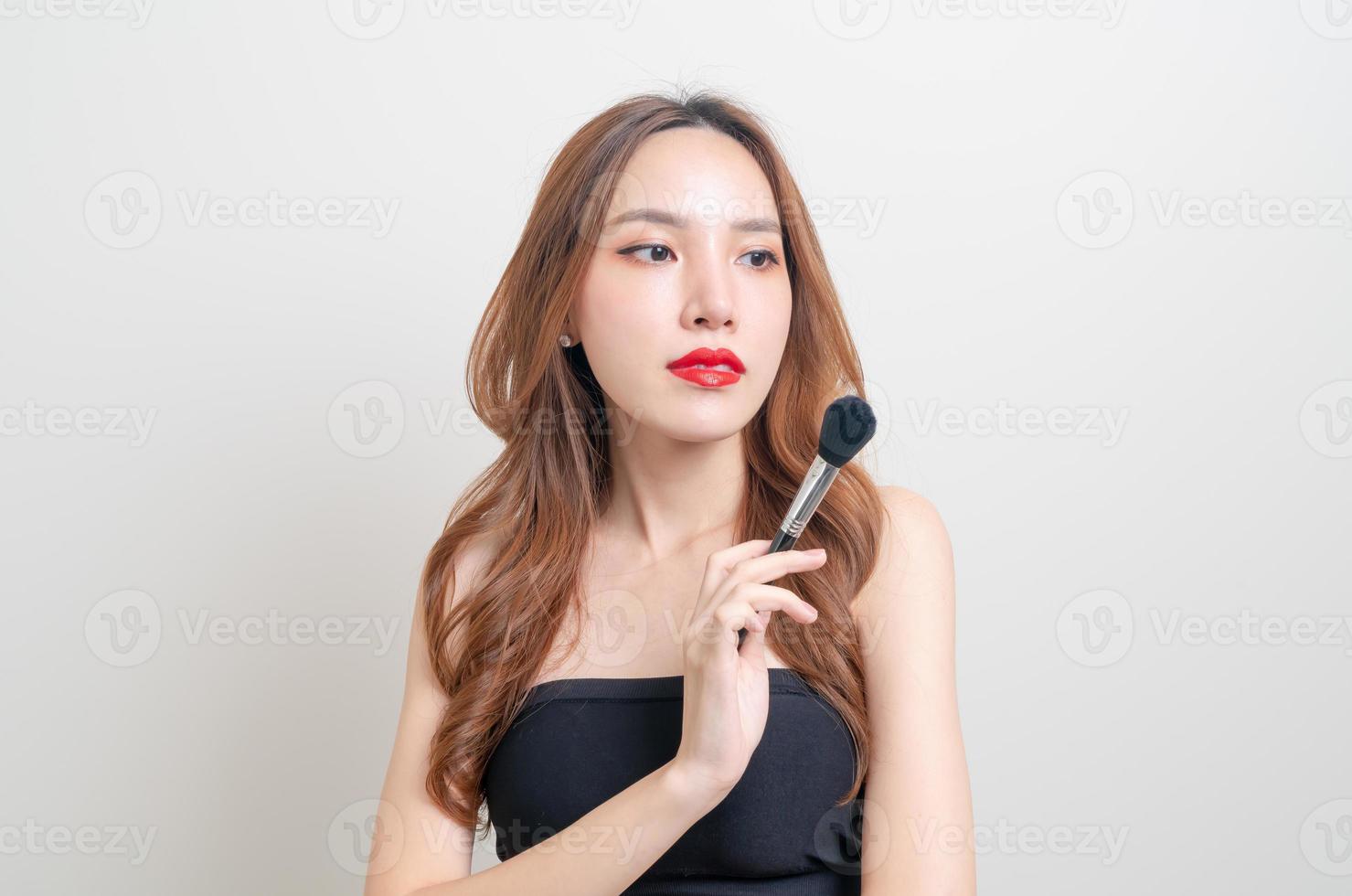 Retrato de mujer hermosa con pincel de maquillaje foto