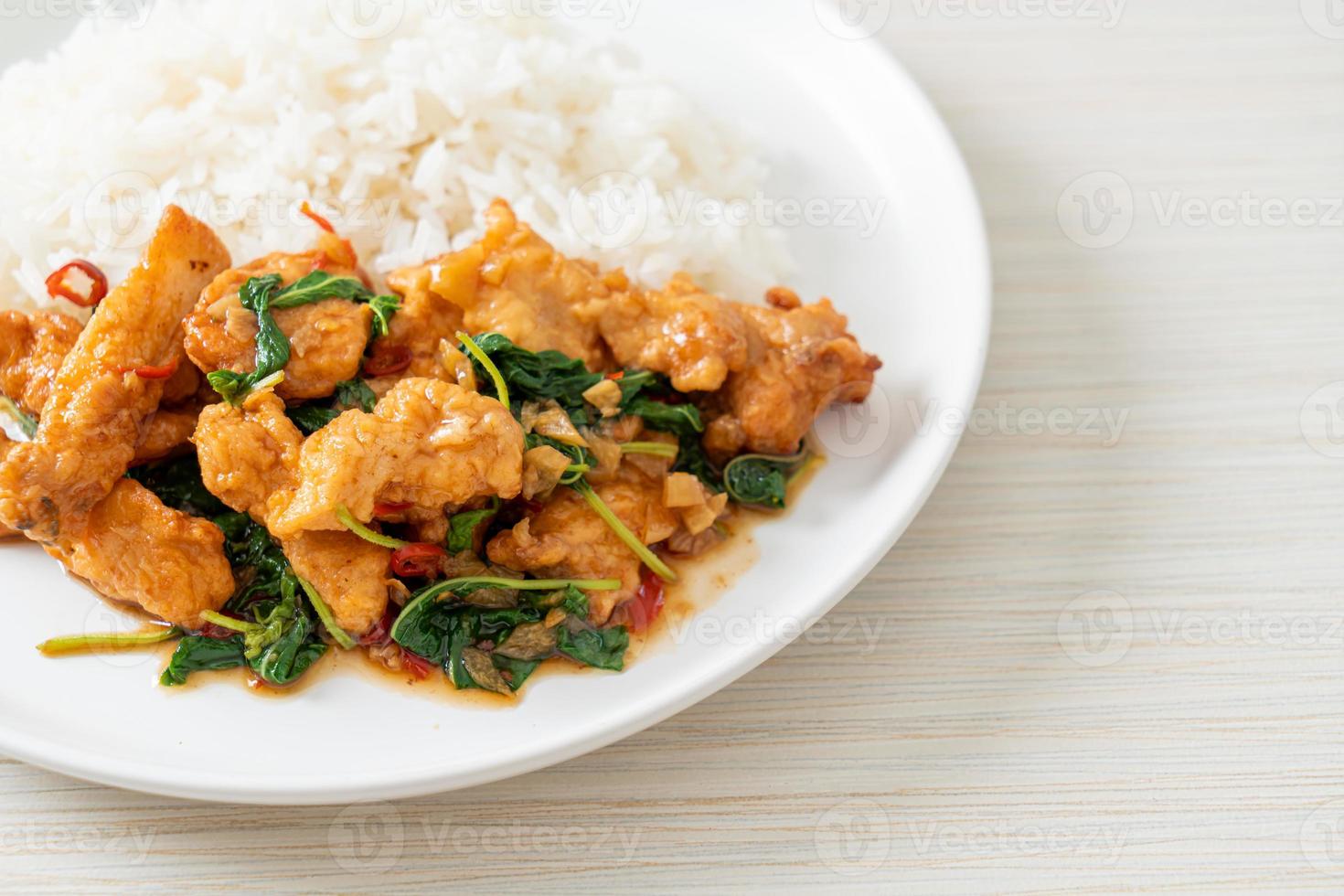 pescado frito salteado con albahaca y chile al estilo tailandés cubierto con arroz foto