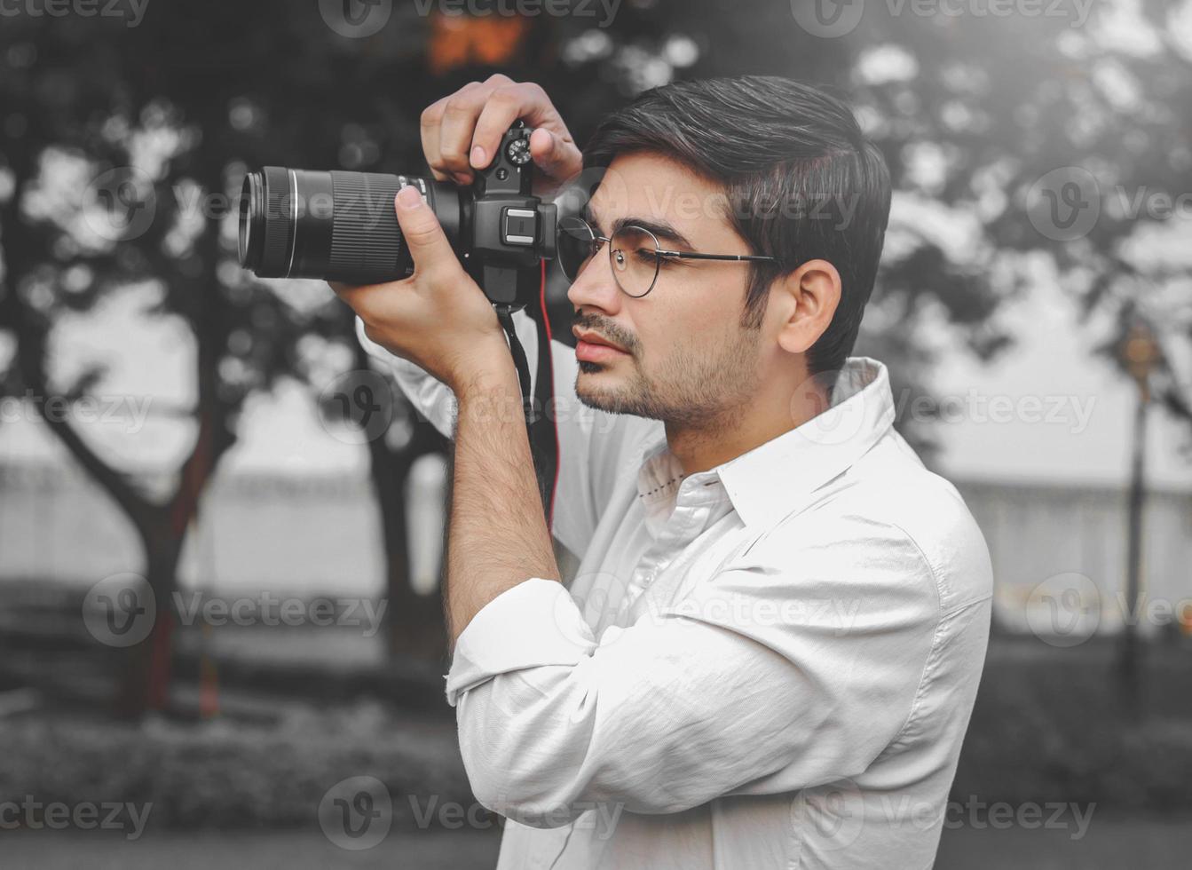 un joven indio capturando el momento de la boda desde la cámara. foto