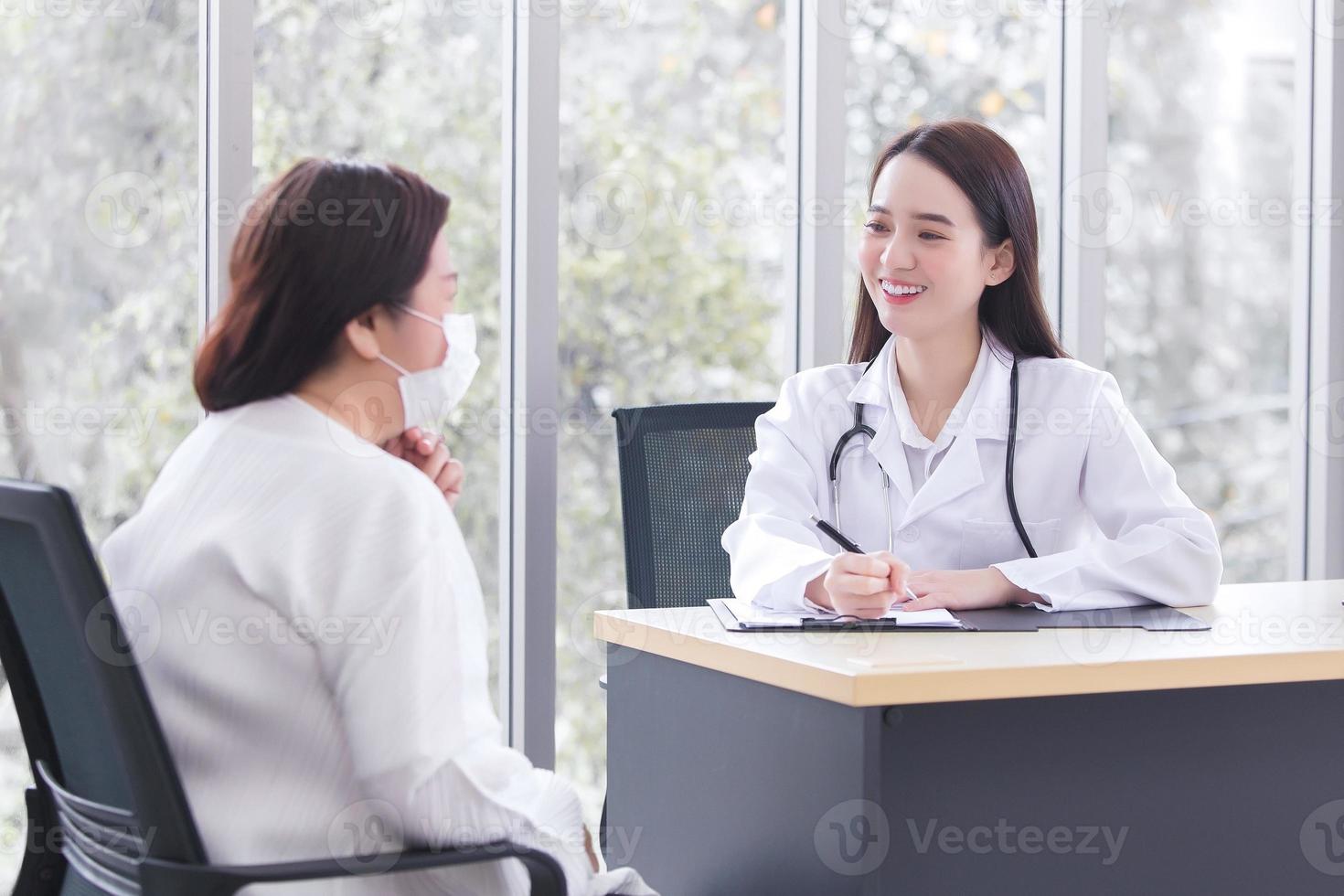 Asian elder woman consults with doctor about her symptom or health problem in examination room at hospital. photo