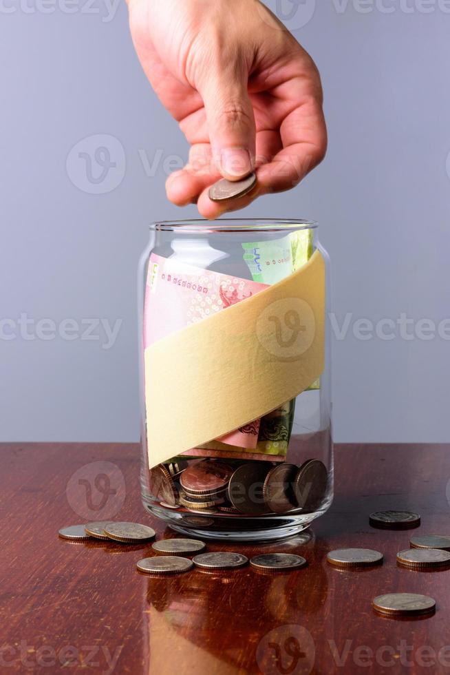 inserte el tarro de monedas de dinero para hacer cosas en la mesa. foto