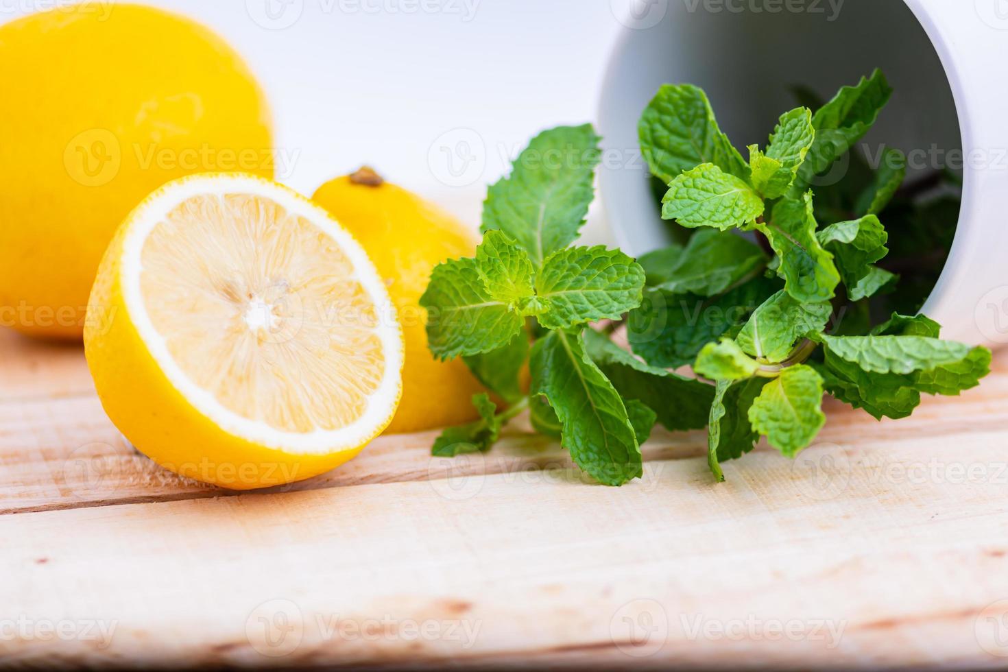 Lemon and Mint placed on a wooden table photo