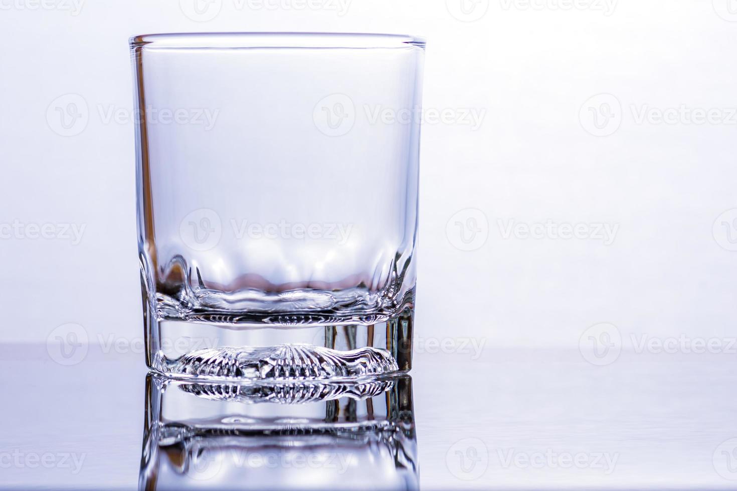 Glass of whiskey on a glass table photo