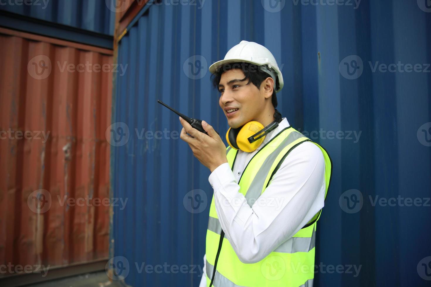 Foreman control loading Containers box from Cargo freight ship for import export. photo