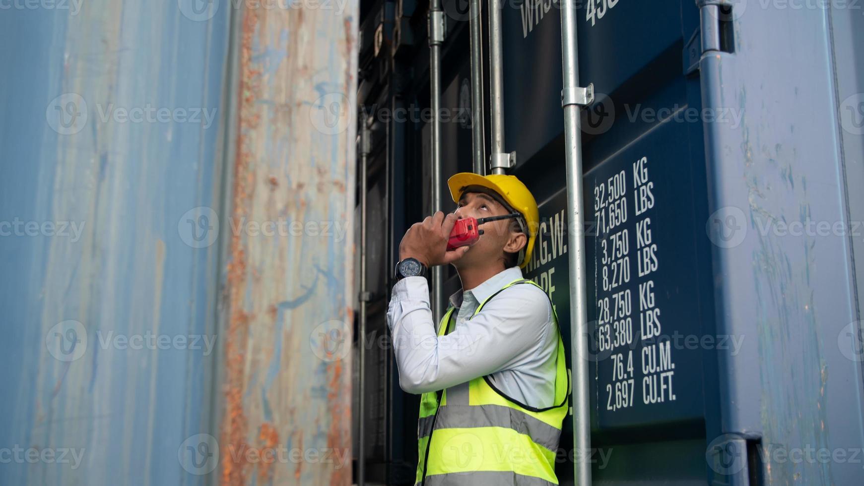 Foreman control loading Containers box from Cargo freight ship for import export. photo