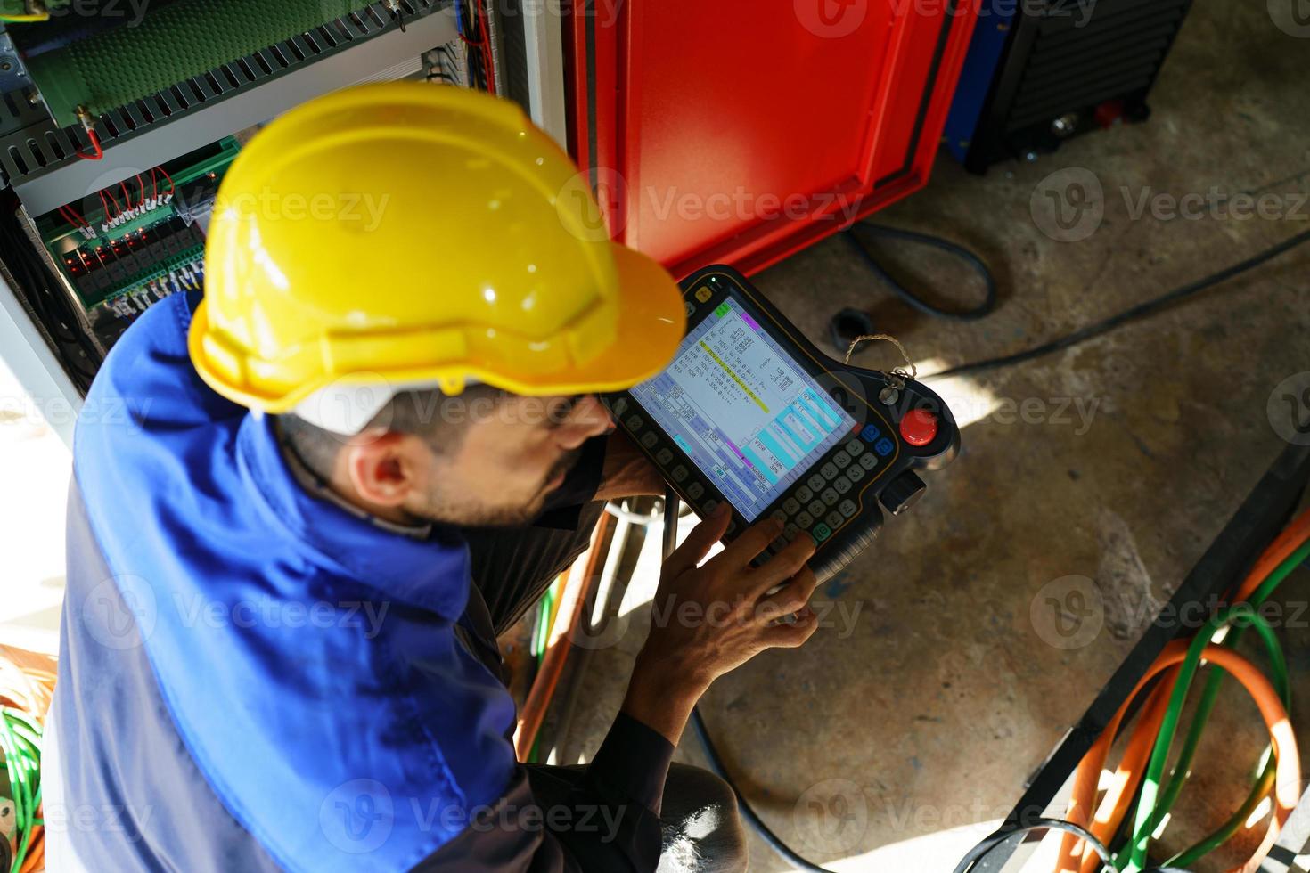 Industrial engineer or worker wearing a helmet while standing in a heavy industrial factory. The Maintenance looking of working at industrial machinery and check security system setup in factory. photo