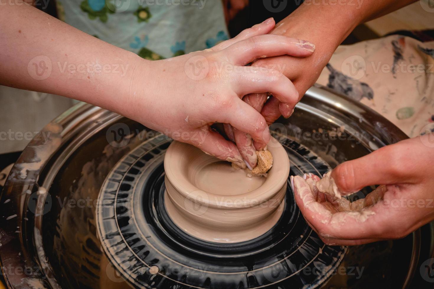 Potter working on potters wheel with clay. Process of making ceramic tableware in pottery workshop. photo