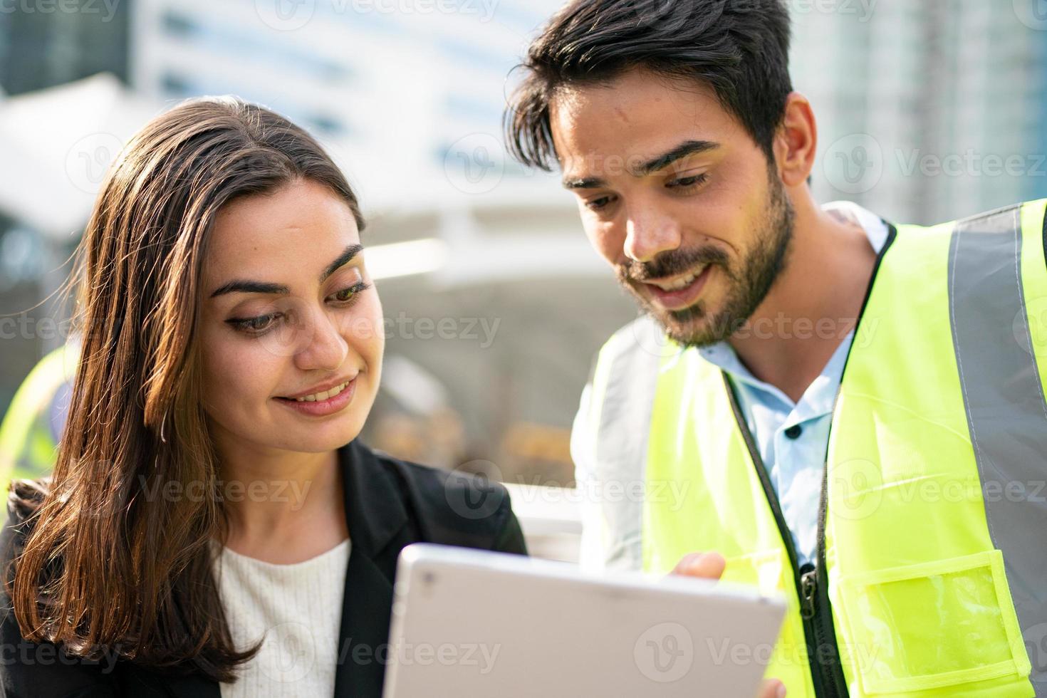 mujer de negocios y trabajador discutiendo con ingeniero en el sitio de construcción. foto