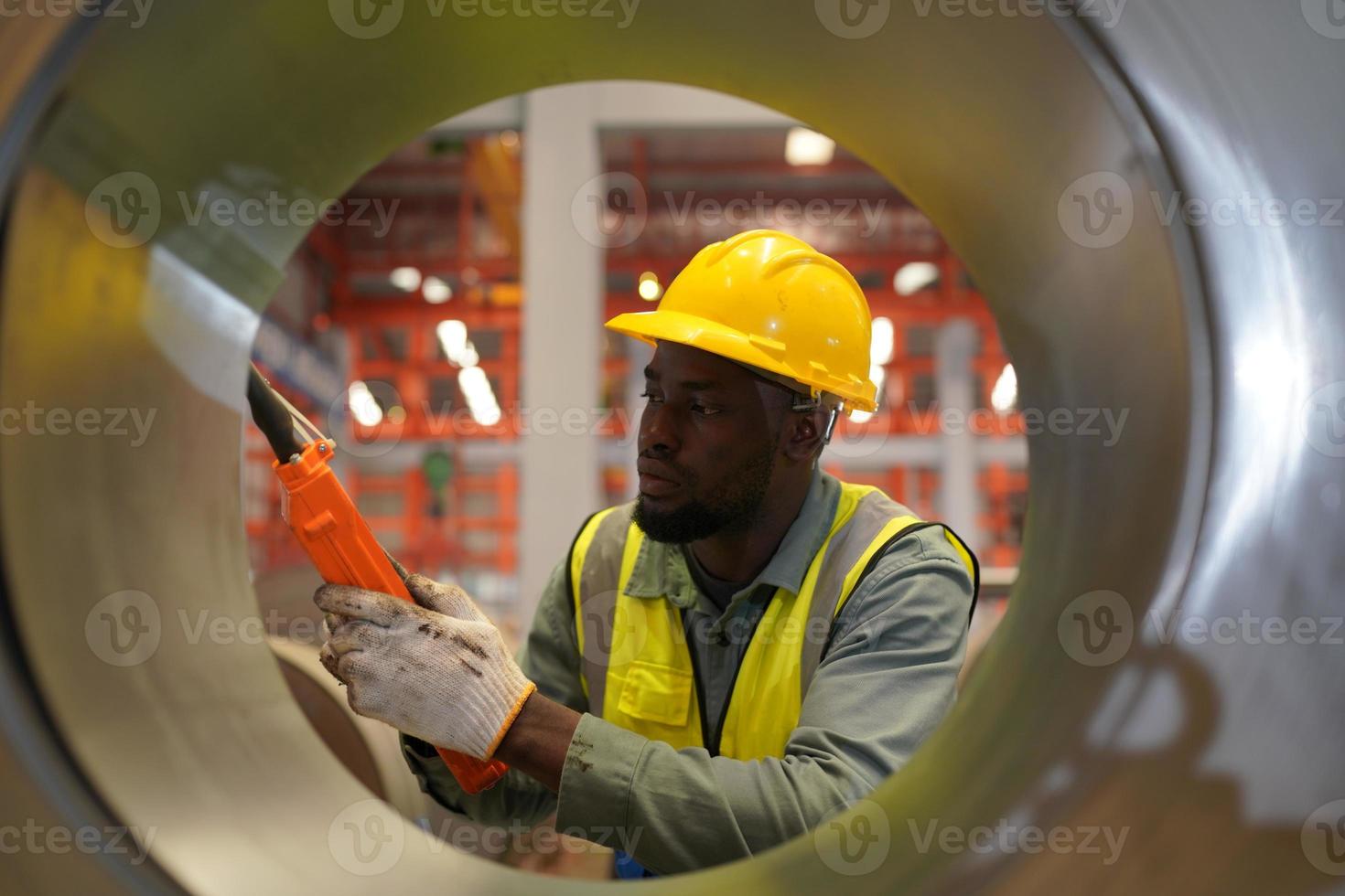 Men industrial engineer wearing a safety helmet while standing in a heavy industrial factory. The Maintenance looking of working at industrial machinery and check security system setup in factory. photo