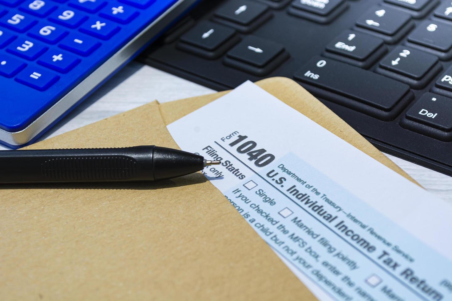 Tax forms 1040. U.S Individual Income Tax Return in an brown envelope on a desk. photo