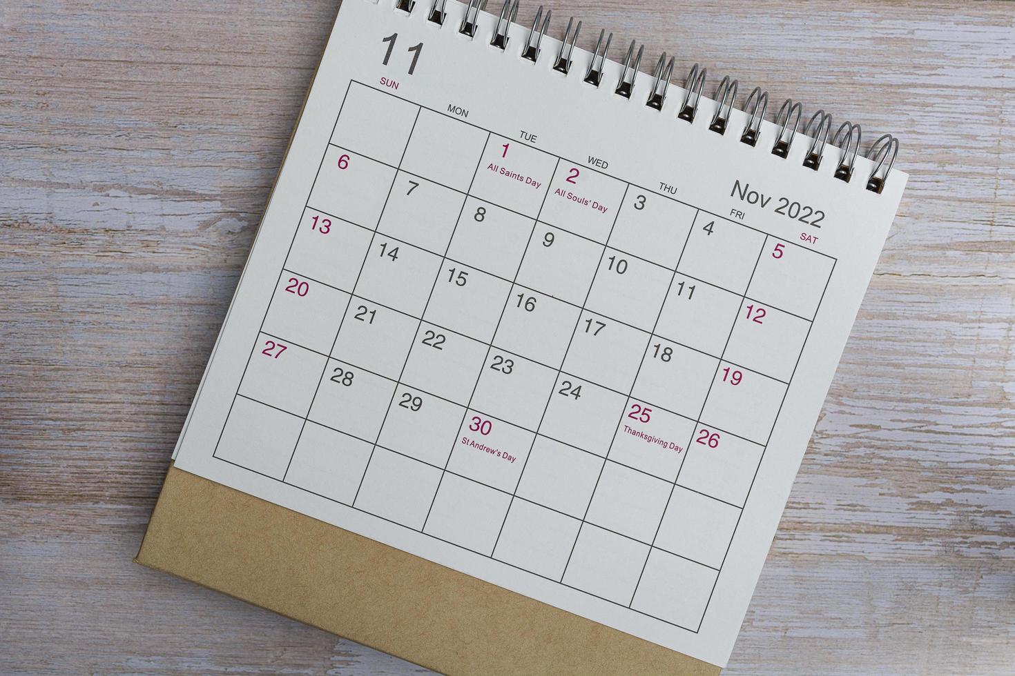 calendario blanco de noviembre de 2022 sobre fondo de madera con eventos festivos diarios. foto