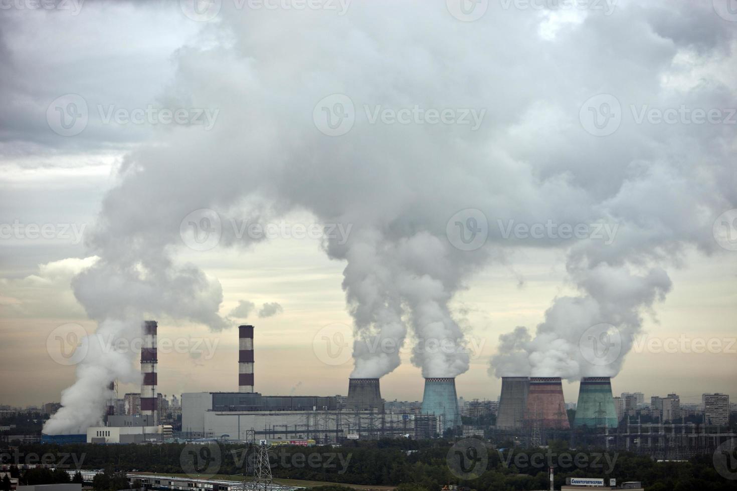 varias chimeneas de la planta de calefacción sueltan columnas de vapor o humo blanco. Calefacción de edificios residenciales, oficinas y empresas. el trabajo de la planta de calefacción de la ciudad foto