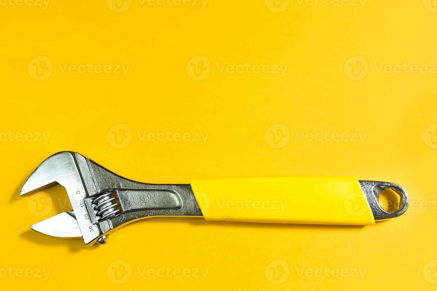 Adjustable universal spanner wrench on yellow background. Construction and repair, plumbing and household appliances, pipes, cars, housing. A tool for an auto mechanic, locksmith, plumber. Copy space photo