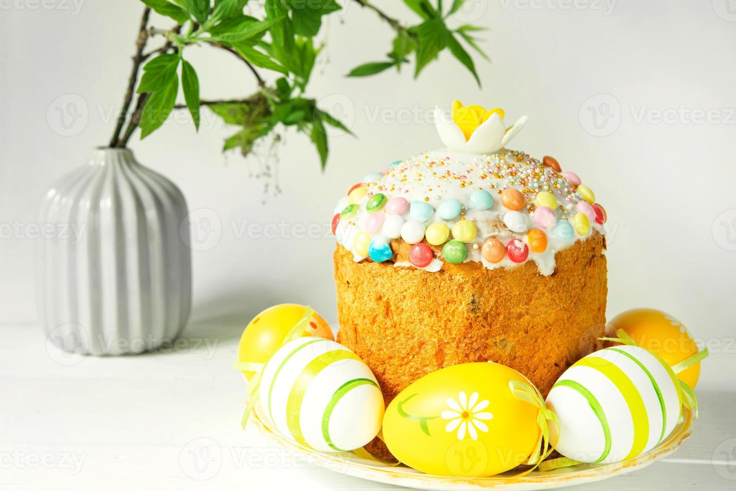 Easter cake with painted eggs on a platter in a gray interior. Traditional festive food photo