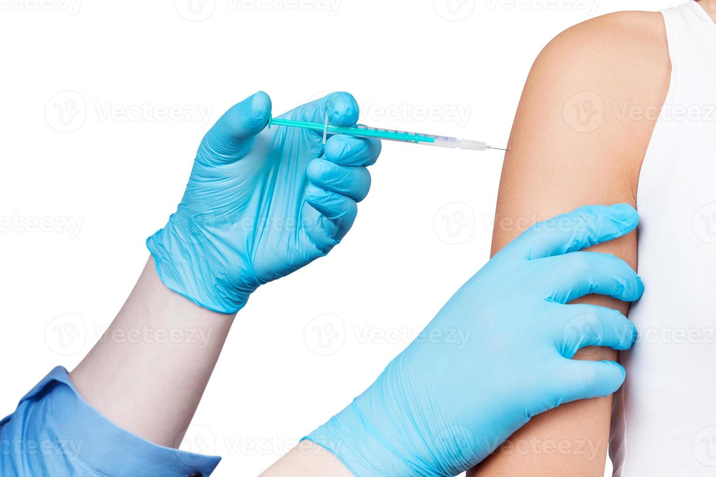 Doctor gives a syringe with vaccine to patient at clinic. photo