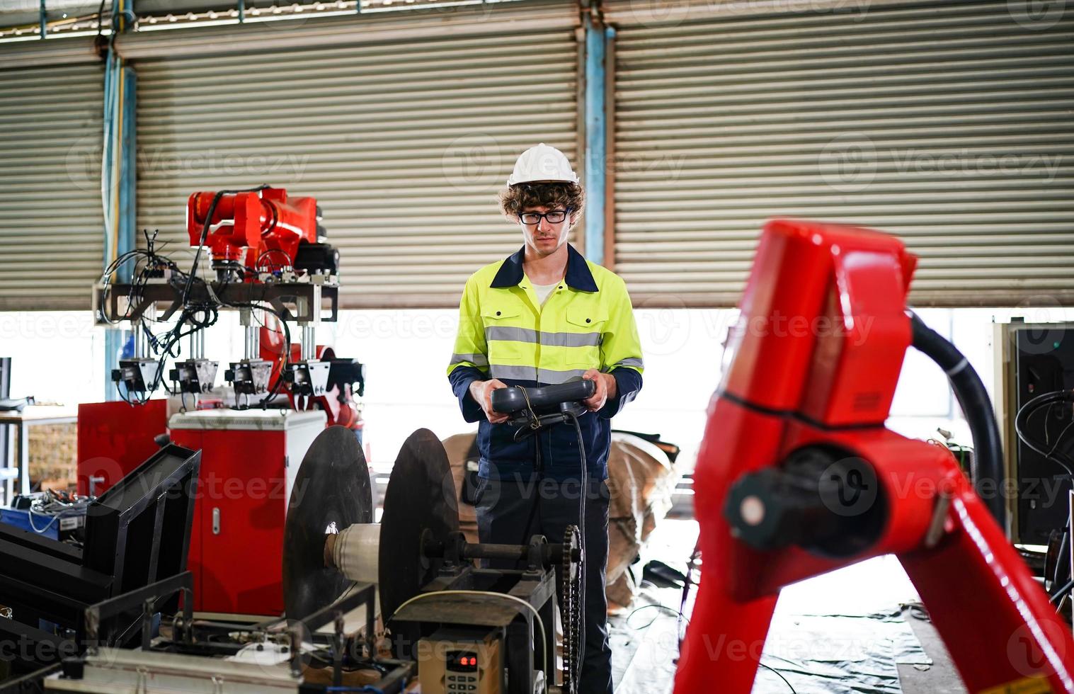 Professional industrial factory employee working with machine part, checking and testing industrial equipment and robot arms in large Electric electronics wire and cable manufacturing plant factory photo