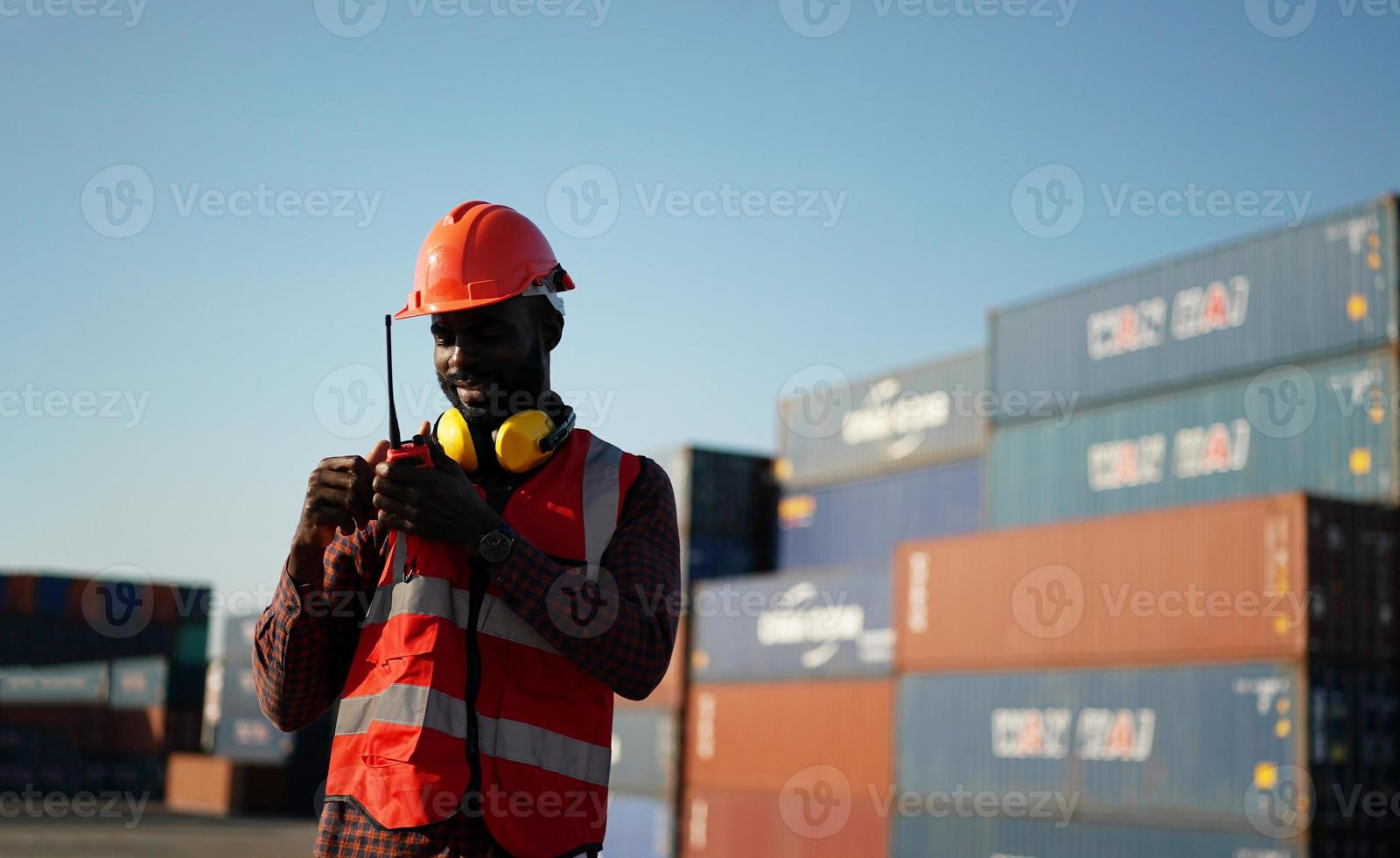 Foreman control loading Containers box from Cargo freight ship for import export. photo