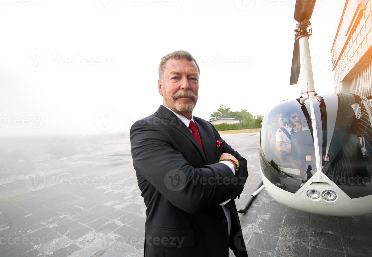 Business people traveling by helicopter , Shot of a mature businessman using a headset while traveling in a helicopter photo