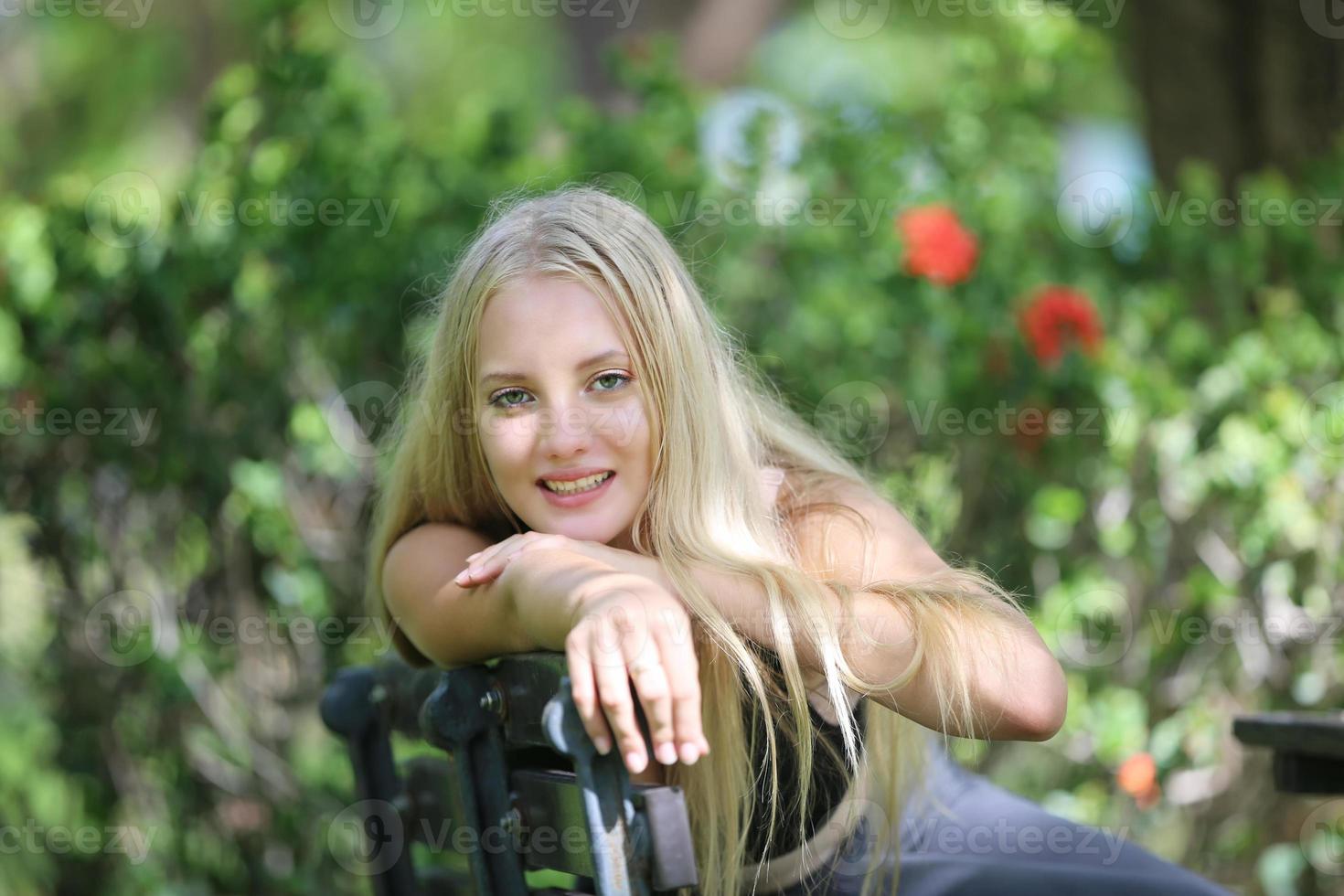 A beautiful woman wearing exercise clothes is playing and enjoying the nature in the garden during the day. photo