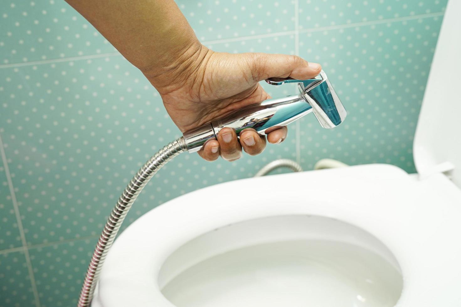 Asian woman patient use toilet bathroom handle security in nursing hospital ward, healthy strong medical concept. photo