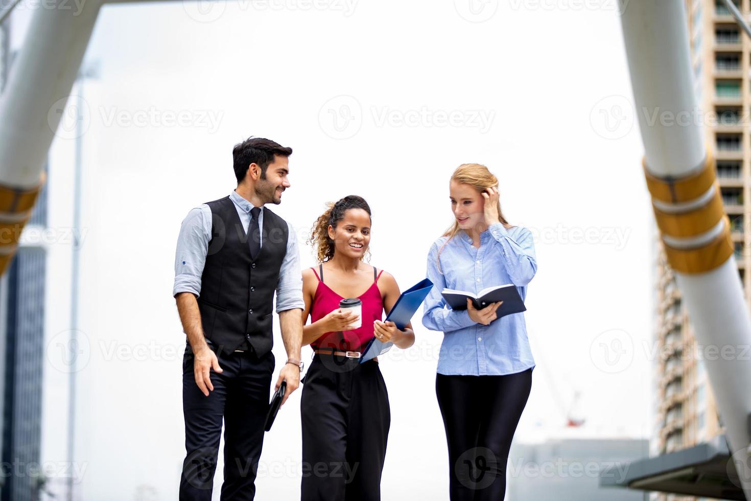 young business people discussing while walking on sidewalk at outside. photo