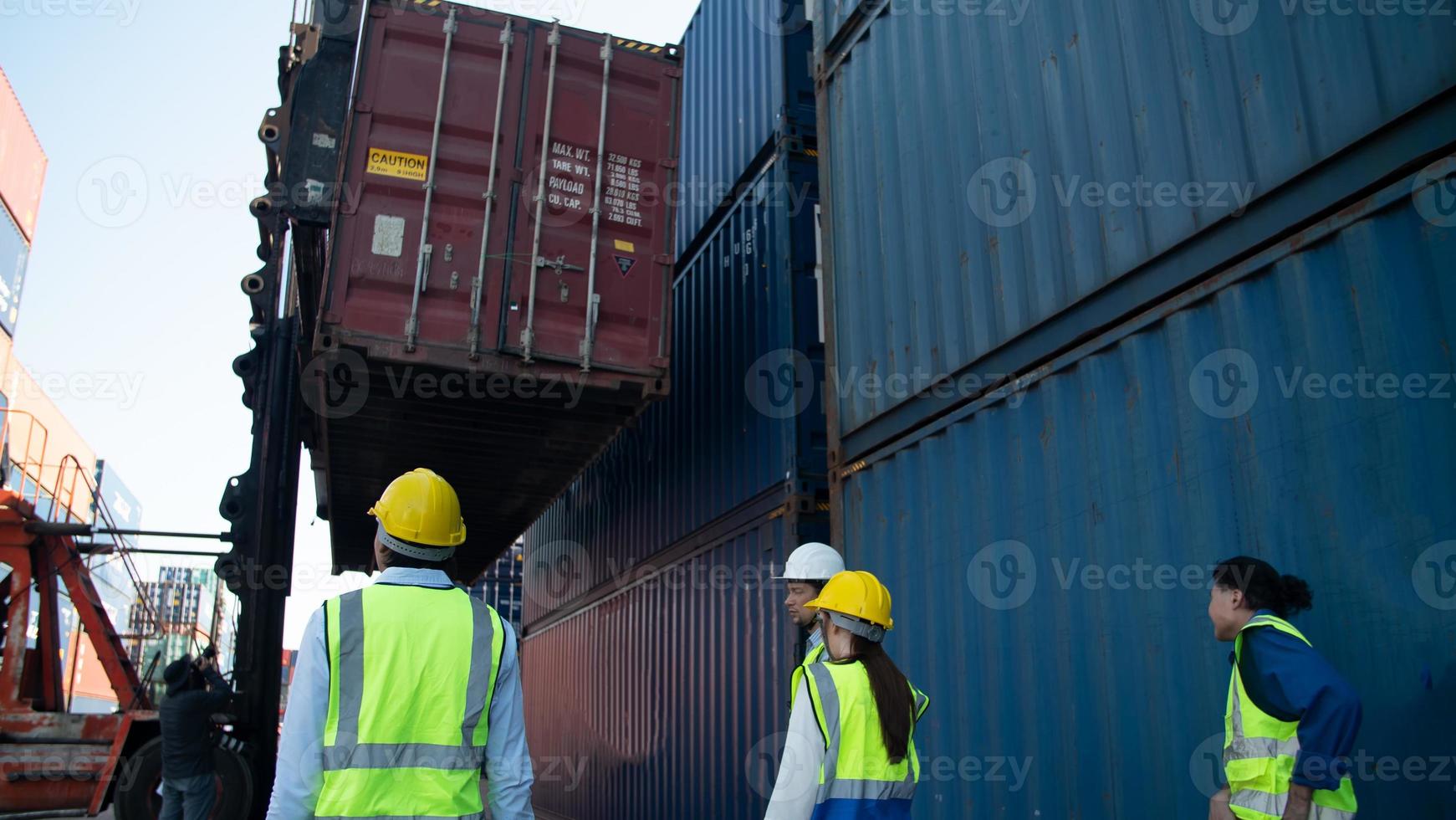 Foreman control loading Containers box from Cargo freight ship for import export. photo