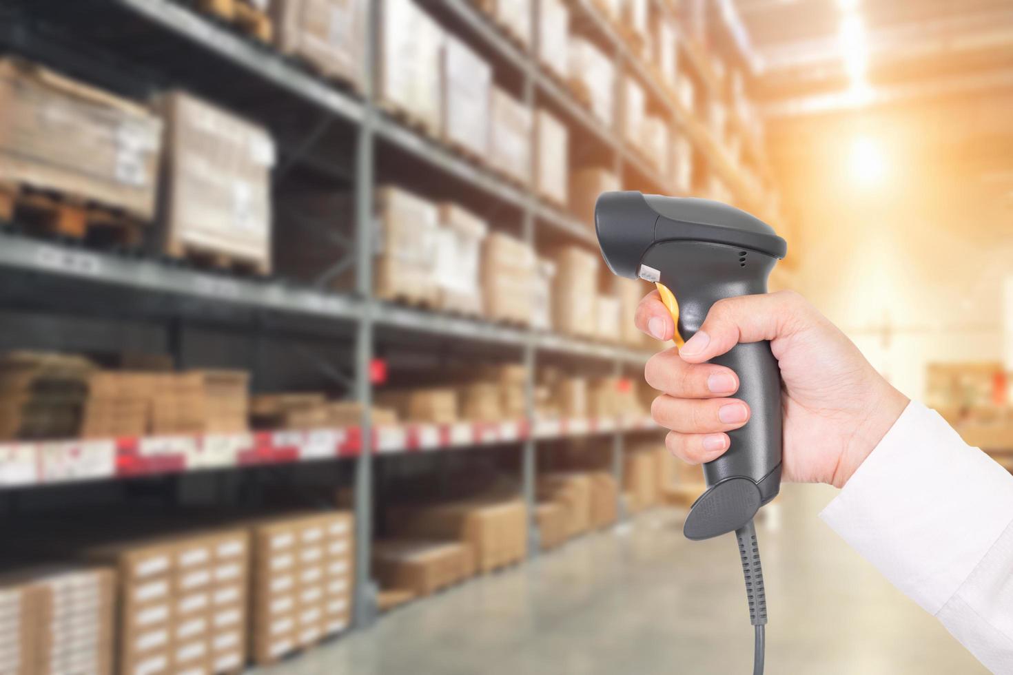 Worker checking and scanning package by laser barcode scanner in modern warehouse. photo