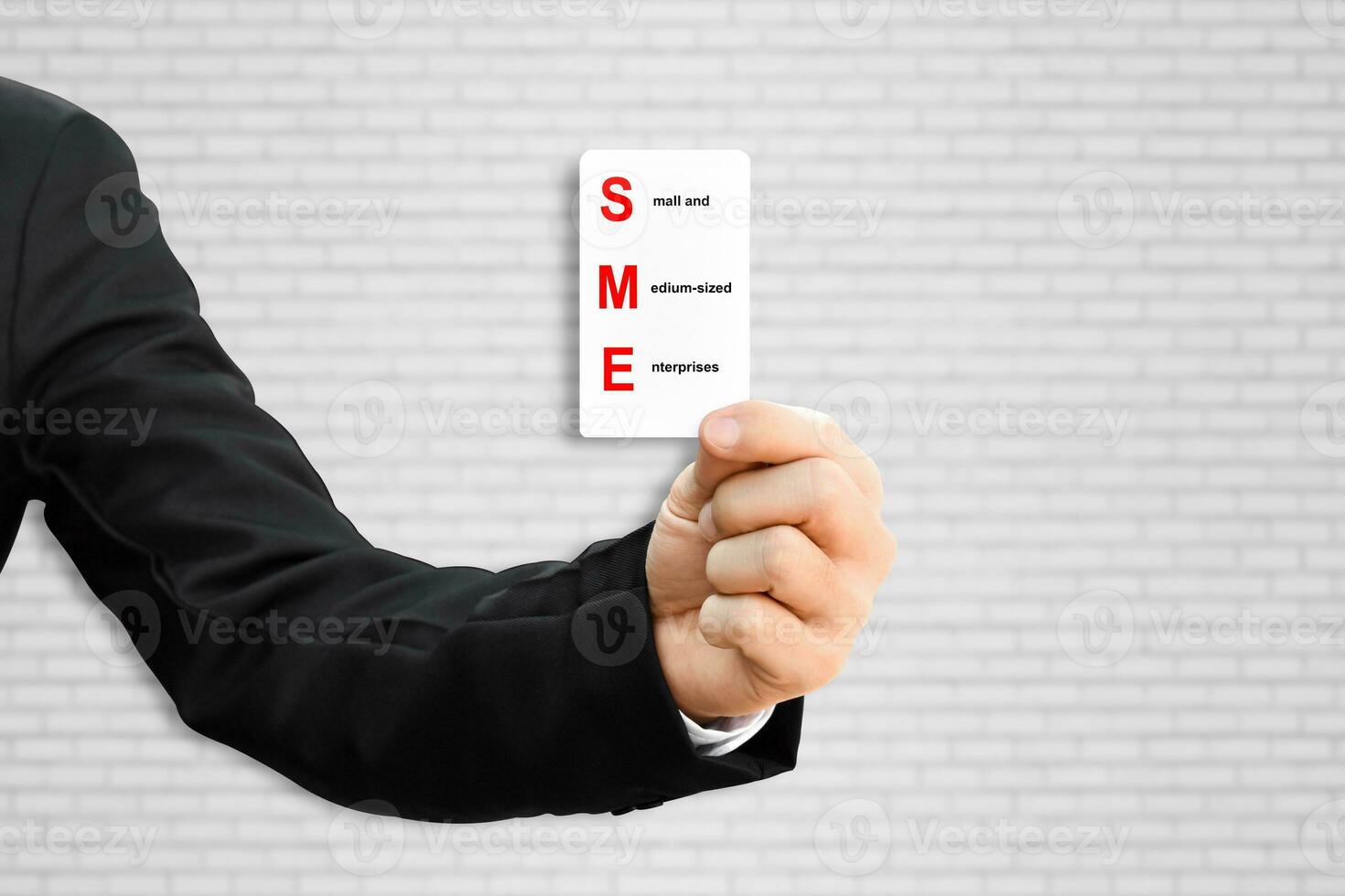 Man hand holding paper card with word SME. Concept of small and medium-sized enterprises business. photo
