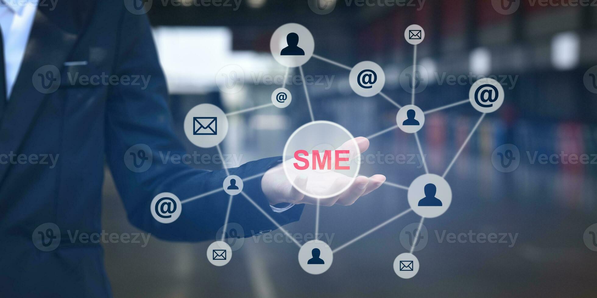 Businessman shows outstretched hand with SME icon on virtual screen. Idea for Small and medium-sized enterprises business. photo