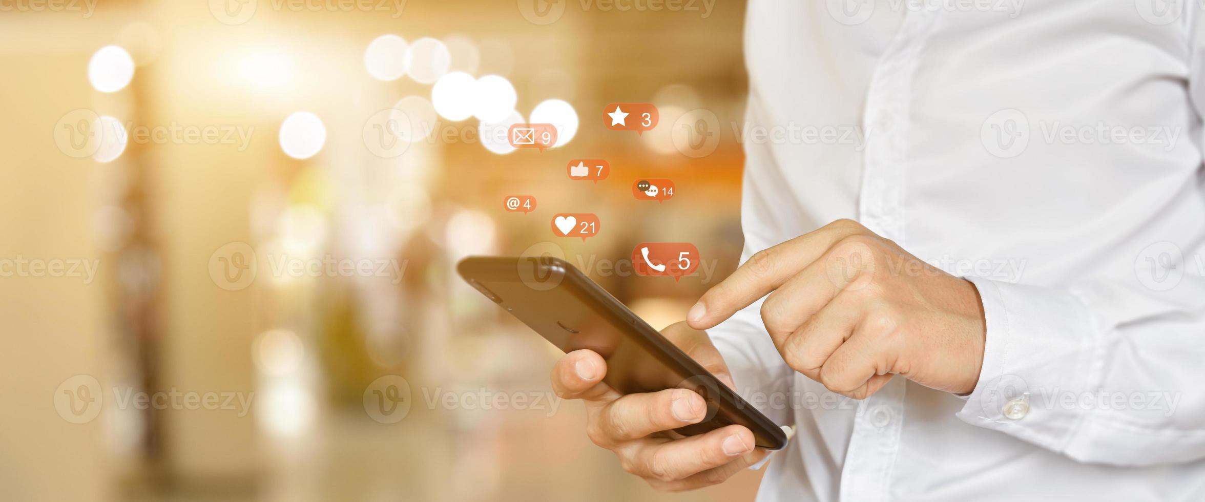 Close up of man using mobile smartphone with social, media icons. Marketing or business technology concept. photo